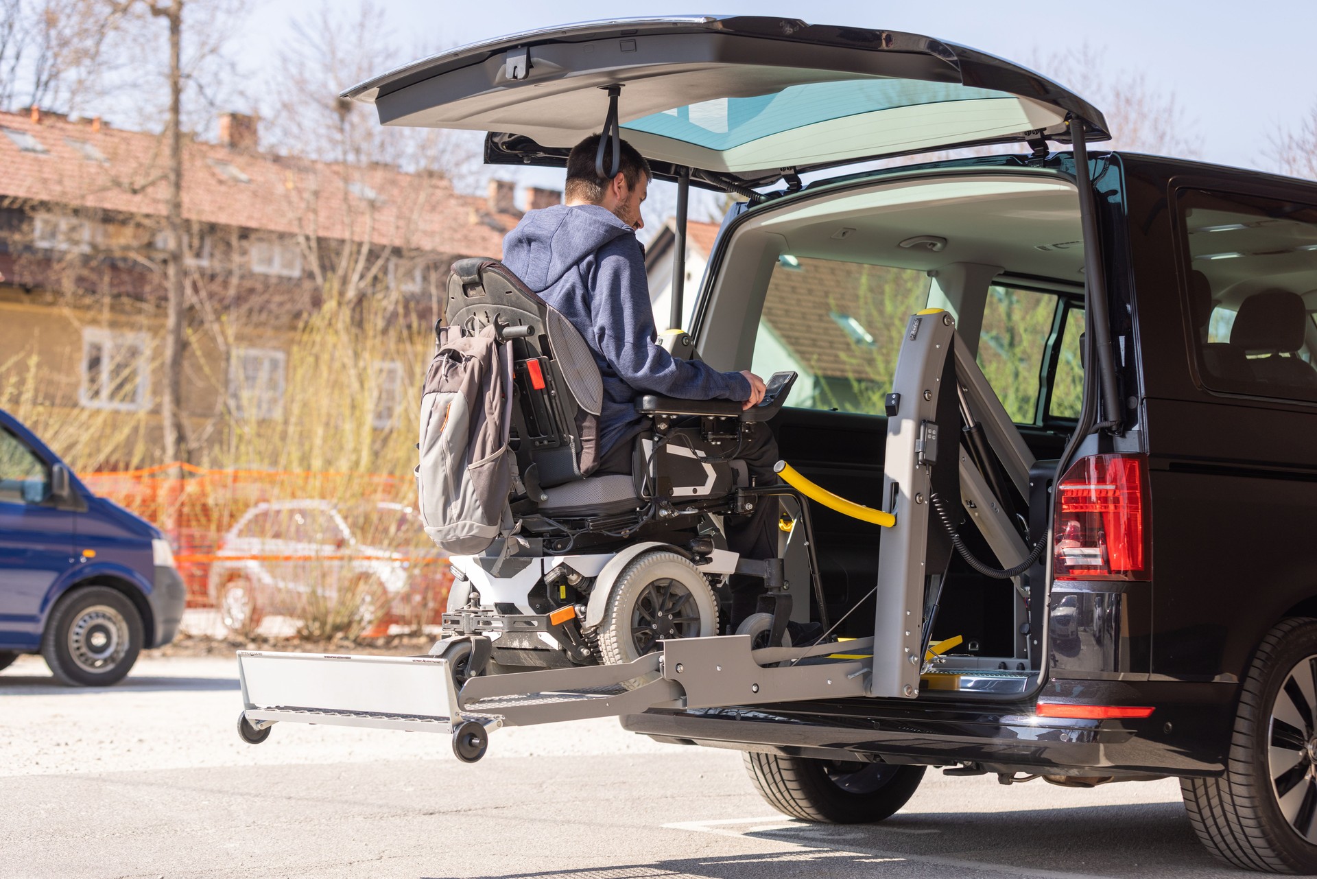 Man with disability using wheelchair lift to get in the van