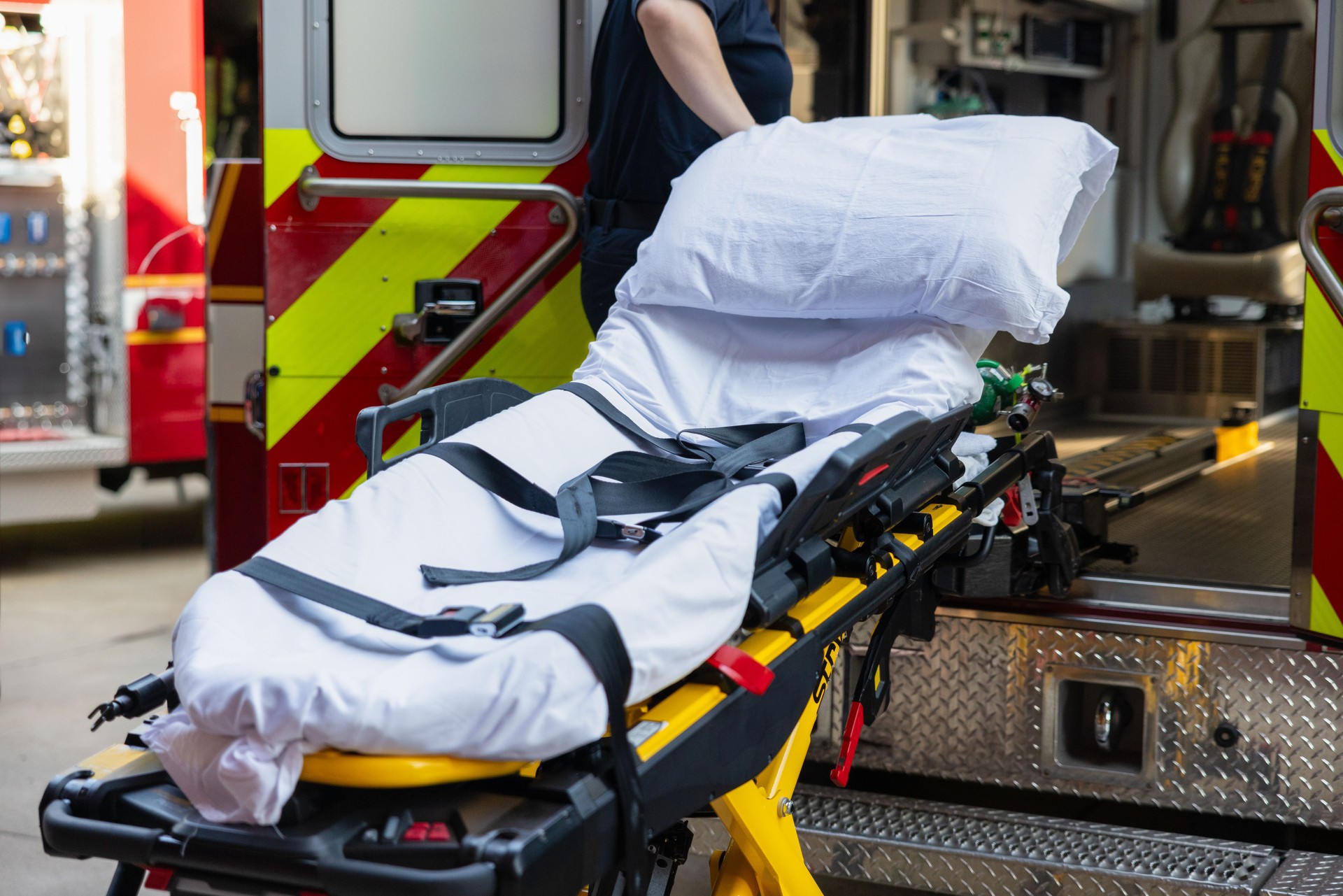 EMT Loads an Empty Stretcher Into the Back of an Ambulance